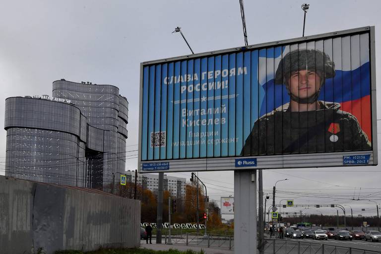 Anúncio mostra soldado russo com o slogan 'glória ao heróis da Rússia' em rua próxima ao prédio do PMC Wagner Centre, associado ao fundado do Grupo Wagner, Ievgeni Prigozhin, em São Petersburgo