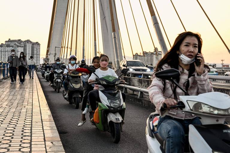 Motociclistas em ponte no lago Lancang, na cidade de Jinghong, na província chinesa de Yunnan