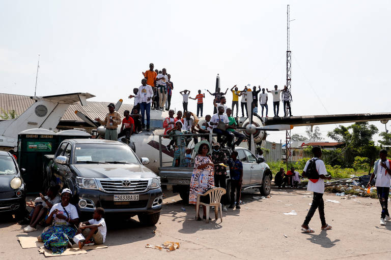 Pessoas em cima de um avião antigo assistem à missa celebrada pelo papa Francisco no aeroporto Ndolo Airport, em Kinshasa, na República Democrática do Congo