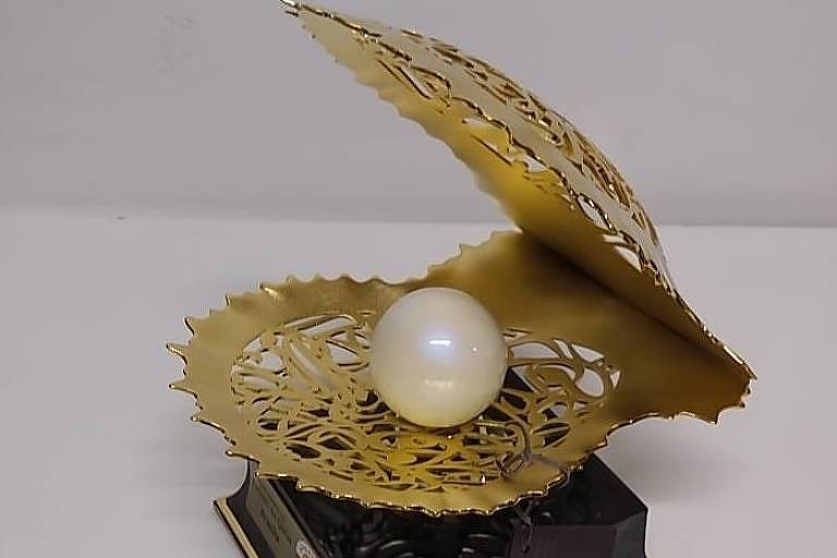 Obra lembra uma concha, de ouro, com uma pérola no meio