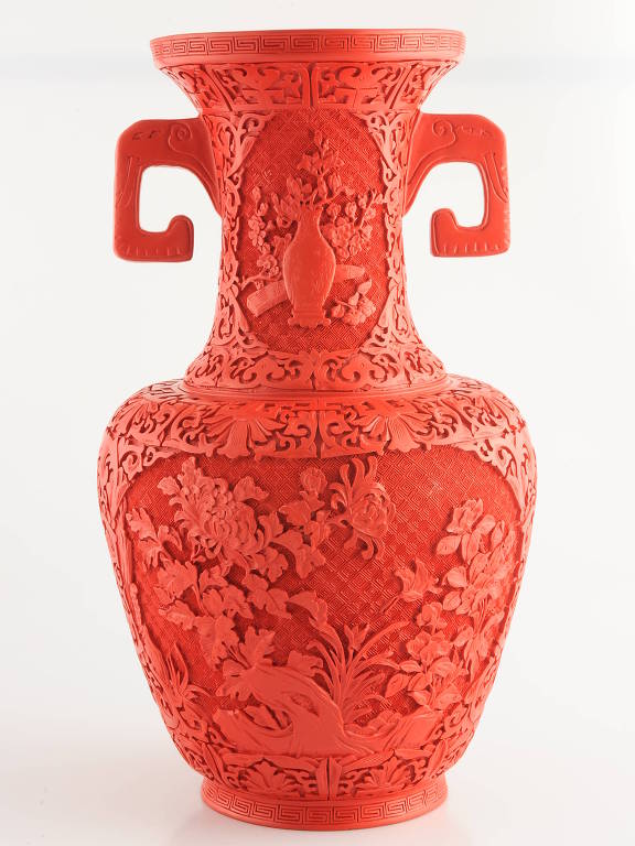 vaso é vermelho, com relevos e duas alças