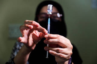 FILE PHOTO: Pharmacist prepares a dose of the coronavirus disease (COVID-19) Pfizer vaccine, in Johannesburg