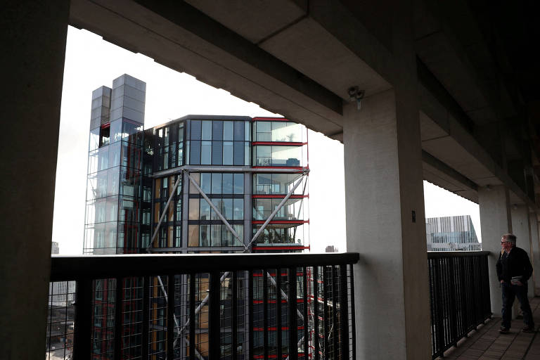 Visitante na galeria de observação do Tate Modern, que permite ver apartamentos de luxo com paredes de vidro na frente