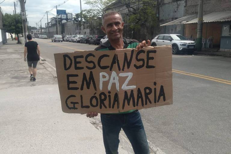 Carlos Henrique do Nascimento, 54, fã da jornalista Glória Maria, levou cartaz em homenagem à repórter em frente ao Cemitério da Penitência, no Caju