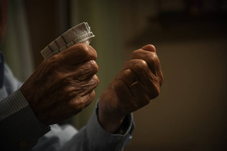 O ex-operário José Vicente Correa, 86, segura lenço que usou para enxugar lágrimas durante entrevista à Folha