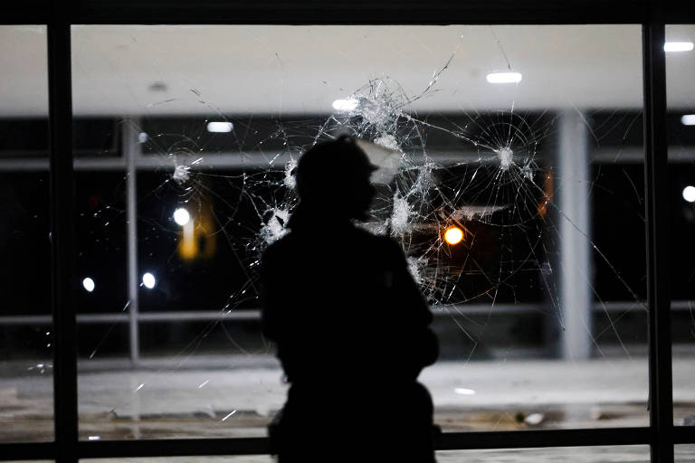 Soldado em frente a painel quebrado no Palácio do Planalto, em Brasília, após ataques golpistas às sedes dos três Poderes
