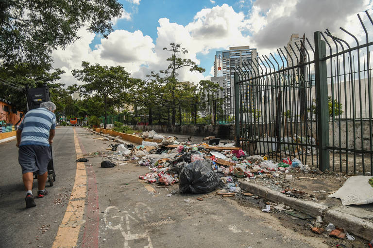 Lixo acumulado na rua Barra Funda, embaixo do viaduto Pacaembu; problema obriga pedestres a andar no asfalto