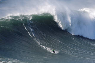 Brazilian skimboarder Lucas Fink rides a wave in Praia do Norte, Nazare