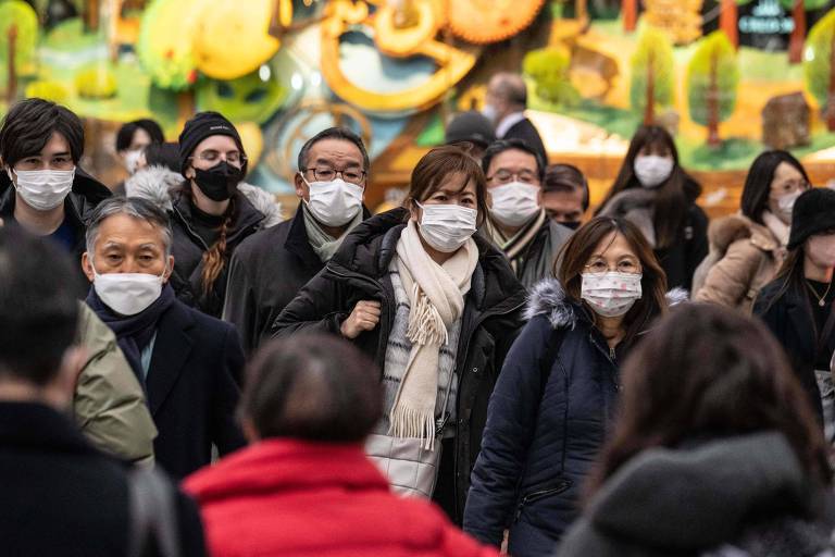 Pedestres usam máscaras faciais em cruzamento de Tóquio