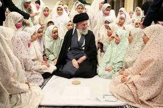 Iran's Supreme Leader Ayatollah Ali Khamenei prays during a meeting with a group of girls in Tehran