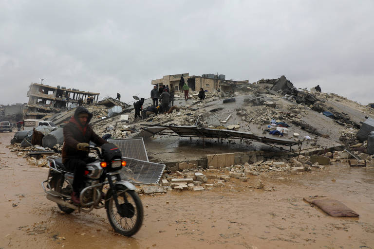 Socorristas buscam sobreviventes em meio a destroços após terremoto na cidade de Jandaris, na Síria