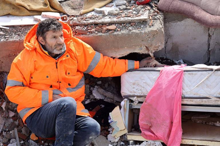 Mesut Hancer segura a mão de sua filha Irmak, 15, morta no terremoto na cidade turca de Kahramanmaras 