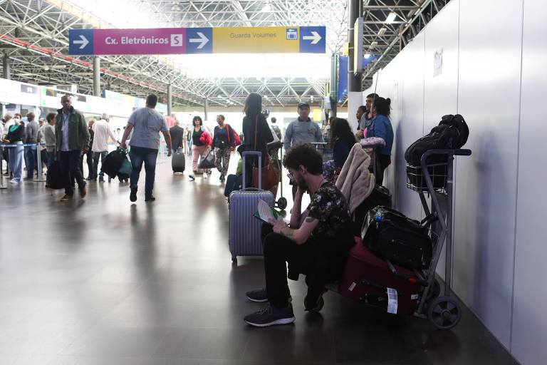 Passageiros aguardam sentados em um saguão do terminal Tietê.