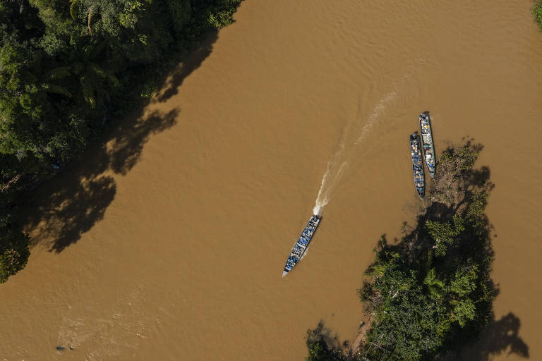 Em uma água barrenta, embarcações carregam galões de combustível até no porto do Arame, no rio Uraricoera, no município de Alta Alegre, em Roraima