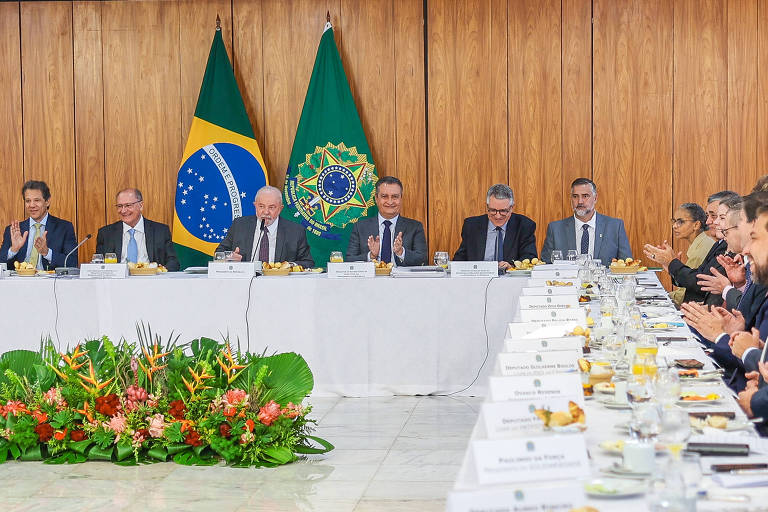 Lula, ministros e parlamentares sentados em torno de uma longa mesa em formato de L