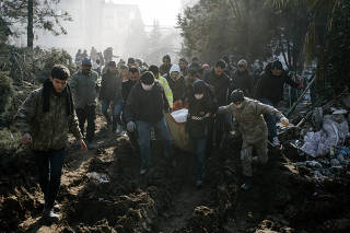 People carry corpses recovered from collapsed building to be buried in Kahramanmaras, Turkey, three days after the earthquake, on Thursday, Feb. 9, 2023. (Emin Ozmen/The New York Times)