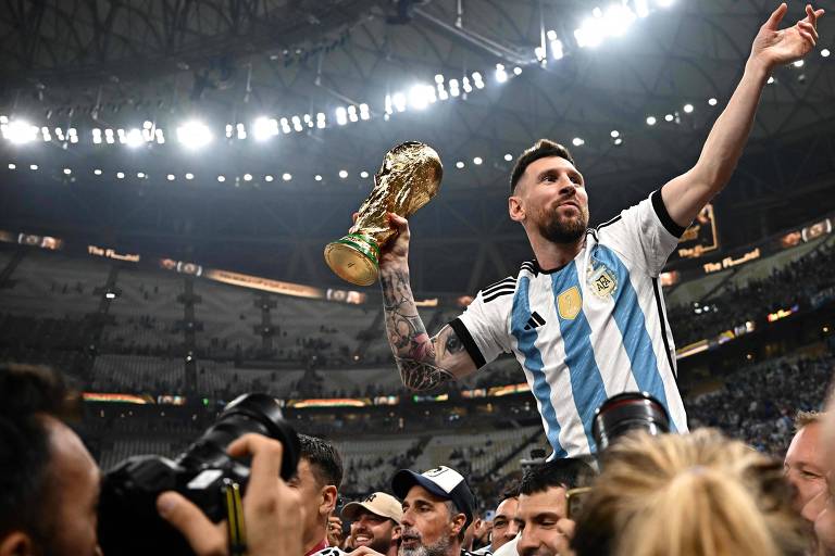 Lionel Messi com a taça de campeão do mundo após vitória sobre a França no Qatar