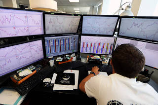FILE PHOTO: A trader looks at screens with graphs and tables at the Diamond trading academy in Nice