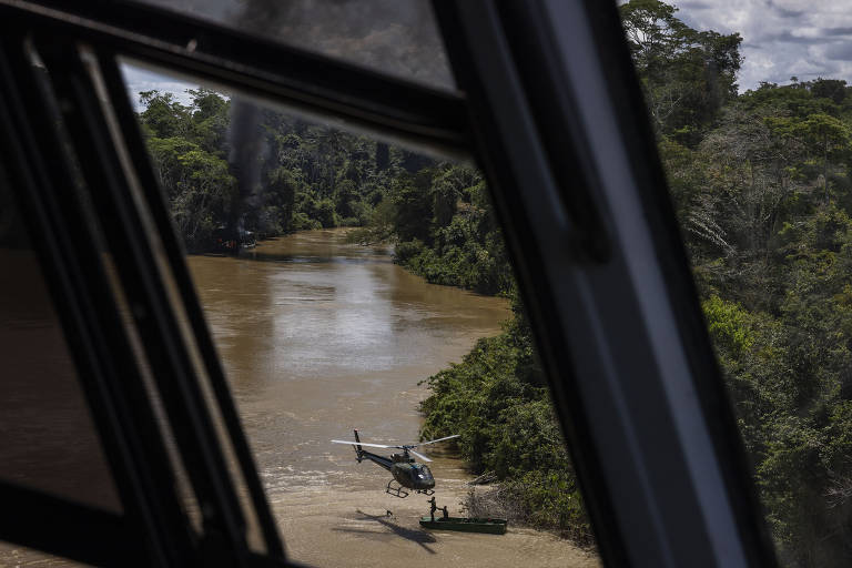Membros do Grupo Especial de Fiscalização do Ibama são resgatados de helicóptero no rio Uraricoera após destruírem uma balsa ilegal de garimpo