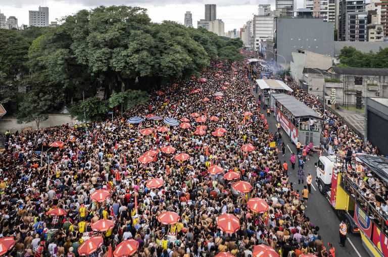 Imagem aérea mostra multidão reunida em uma avenida.