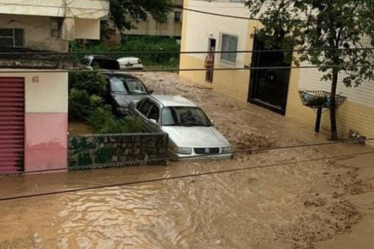 Imagem colorida mostra um carro afundado em enchente após forte chuva em Barra do Piraí