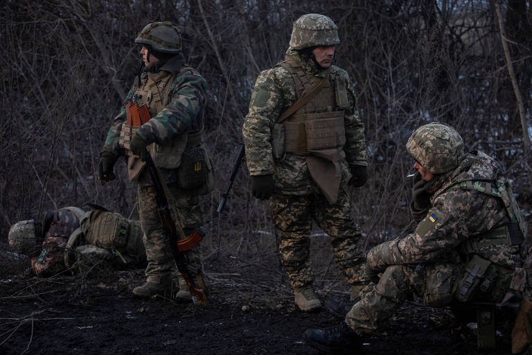 Soldados ucranianos descansam em uma estrada próxima de Bakhmut, cidade sob ataque russo