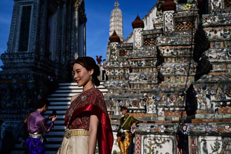 Uma turista de Taiwan posa junto ao templo budista Wat Arun, em Bancoc, na Tailândia