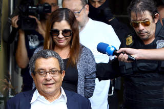 Joao Santana, Brazilian President Dilma Rousseff's campaign chief and his wife Monica Moura, are escorted by federal police officers as he leaves the Institute of Forensic Science in Curitiba
