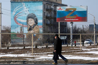FILE PHOTO: A pedestrian walks near a pro-Russian banner in Chernomorskoye