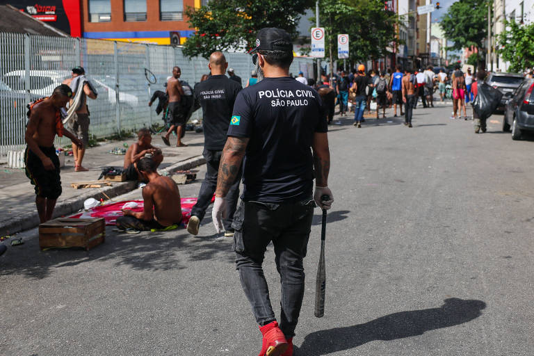 Policial civil caminha com taco de beisebol durante ação na cracolândia