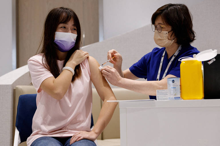Yoyo Liang, residente da China continental, recebe dose de vacina da BioNTech contra o coronavírus em uma clínica privada em Hong Kong