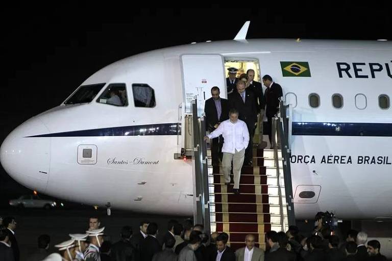 Um grupo de pessoas desce as escadas de um avião
