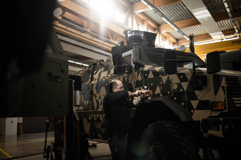Homem faz manutenção em veículo de reconhecimento em base militar de Luxemburgo