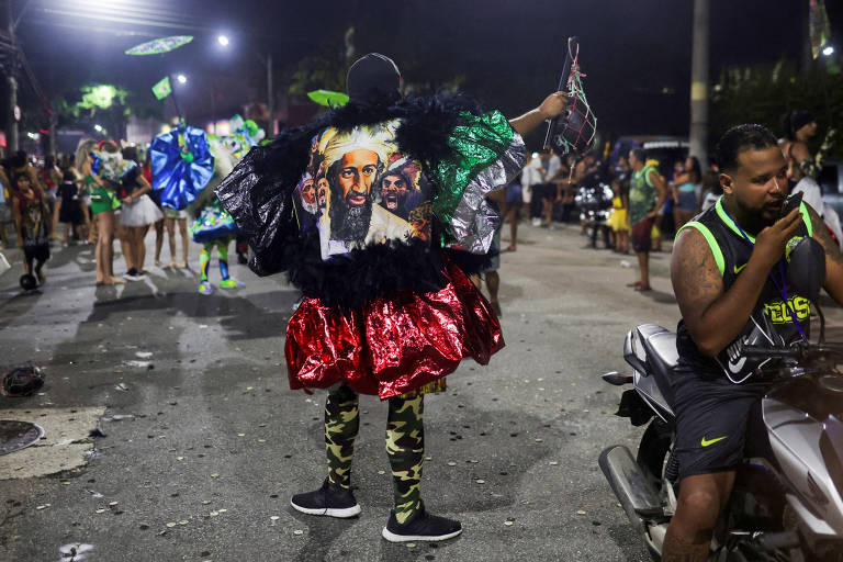 Um folião do "Bate-bola" (bate a bola) veste uma fantasia com um desenho de Osama Bin Laden enquanto se apresenta durante a tradicional festa carnavalesca em um subúrbio do Rio de Janeiro