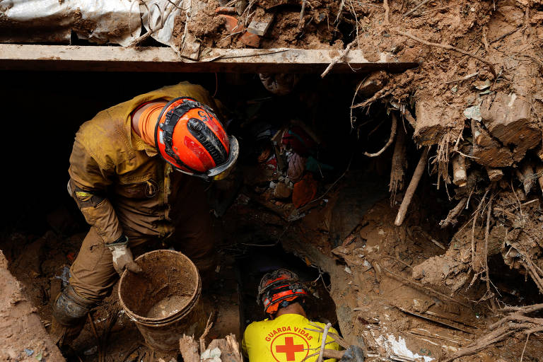 Bombeiros escavam para tentar encontrar os corpos de pessoas desaparecidas durante a tempestade que atingiu barra do Sahy, em São Sebastião, no litoral norte de São Paulo