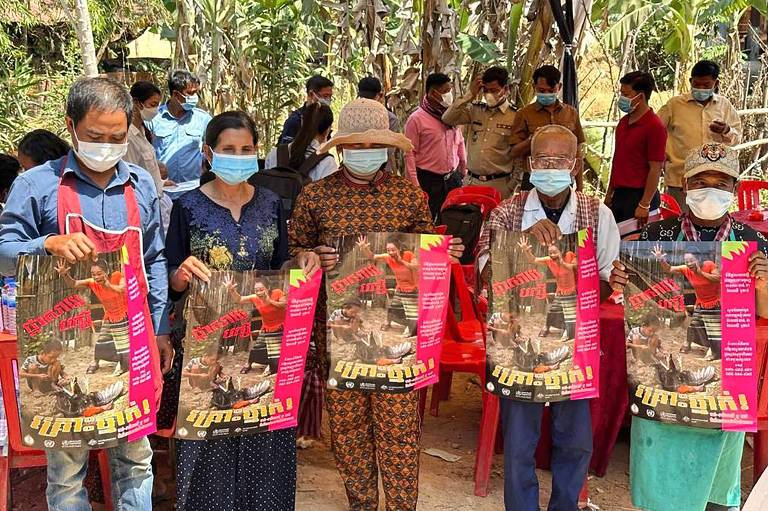Moradores da província de Prey Veng, no Camboja, mostram cartazes com alerta contra a gripe aviária H5N1, que, segundo as autoridades sanitárias do país, vitimou uma menina de 11 anos na cidade