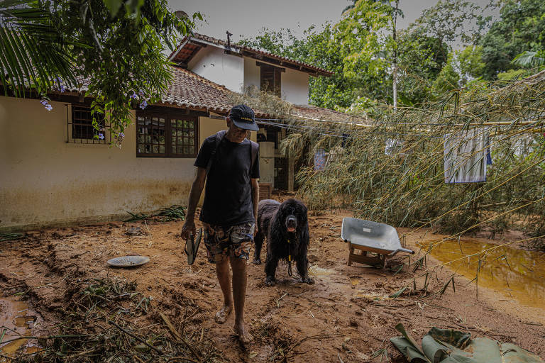 O arquiteto Fábio Marangolo, 64, e seu cão Black sobem o morro para chegar a sua casa, que fica na região de residências de alto padrão na barra do Sahy, em São Sebastião