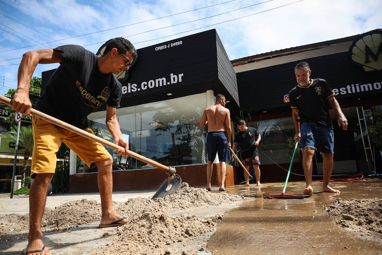Funcionários de imobiliária em Juquehy, em São Sebastião, retiram lama após temporal histórico que provocou alagamentos e mortes