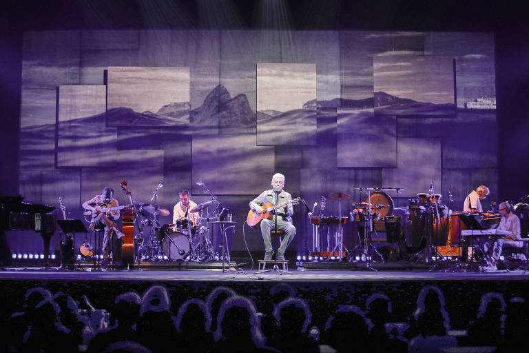 Chico Buarque durante show da turnê "Que Tal um Samba?", iniciada em 2022. Ao fundo, foto feita por Marina Juppa compõe o cenário
