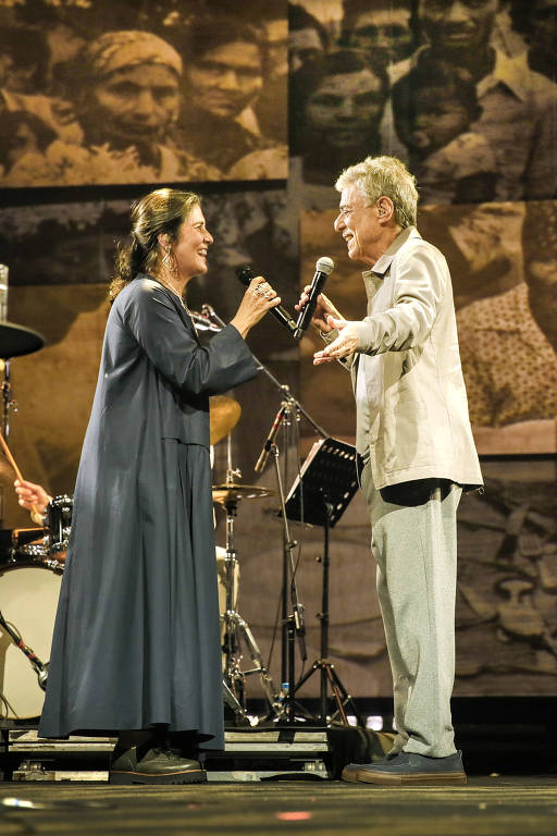 Mônica Salmaso e Chico Buarque durante show da turnê "Que Tal um Samba?", iniciada em 2022. Ao fundo, foto feita por Sebastião Salgado compõe o cenário