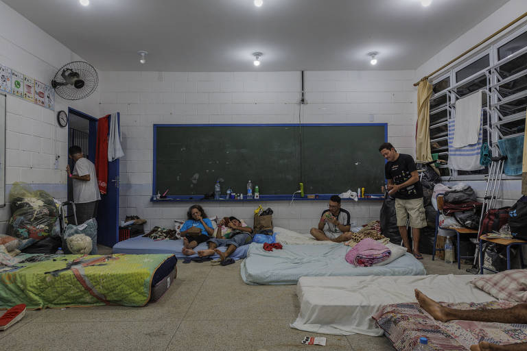 Desabrigados transformam salas de aula em escola municipal em dormitório