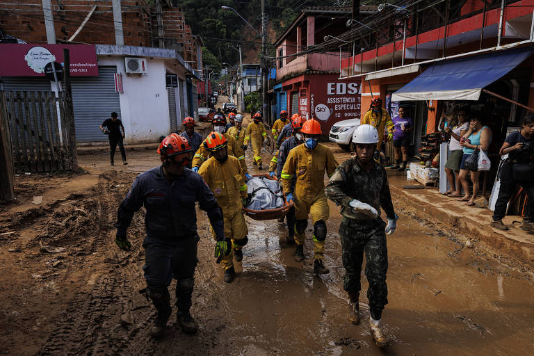 Bombeiros, exército e voluntários trabalham no resgate de vítimas dos deslizamentos causados por forte chuva no litoral  norte de São Paulo. Na foto, socorristas tiram mais uma vitima dos escombros