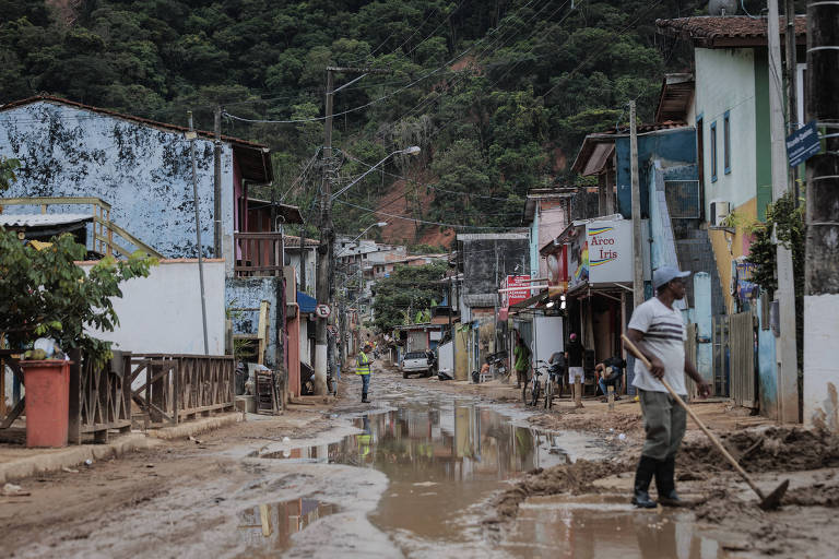 Moradores limpam lama das ruas da barra do Sahy, a região mais devastada pelas chuvas no litoral norte de São Paulo