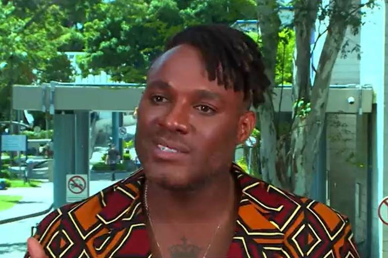 Em foto colorida, homem negro explica em entrevista sobre a sua saída de um reality show