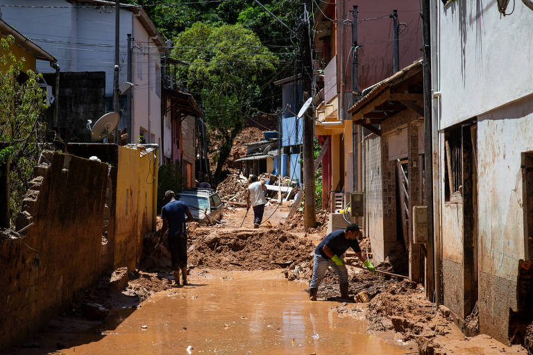 foto mostra rua da vila sahy, em são sebastião, com lama e água no meio e nas portas das casas
