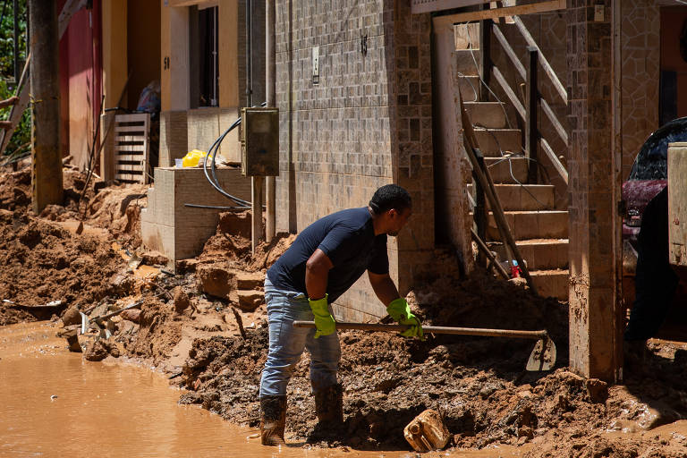 Moradores retiram lama de ruas de São Sebastião (SP) após deslizamentos