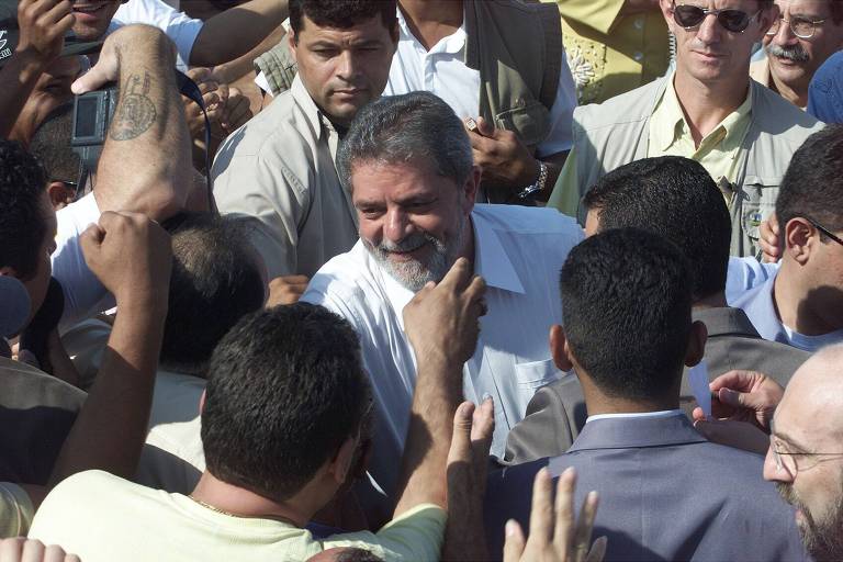 O presidente Luiz Inácio Lula da Silva é cumprimentado por moradores no lançamento das obras de 200 casas populares em Rondonópolis (MT), em 2003