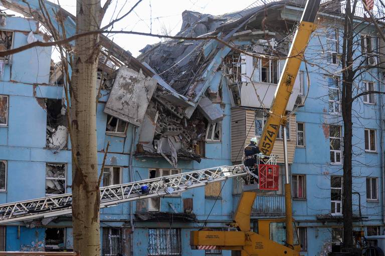 Bombeiro ucraniano trabalha no resgate em prédio atingido por míssil russo em Zaporíjia