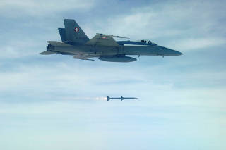 FILE PHOTO: Undated handout picture shows Swiss Air force F/A 18 fighter jet firing an AMRAAM AIM-120C-7 Air-to-Air Missile of the Swiss Army armament program for 2011
