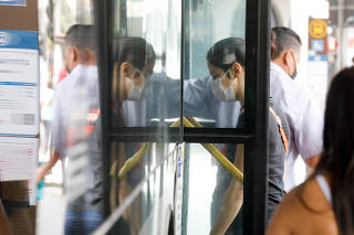Passageiros com máscaras no terminal de ônibus da estação Santana do metrô